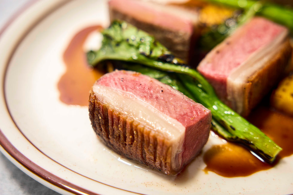 Capturing the richness of the dish, balancing the visual contrast between the cast iron pot and the vibrant sauce.