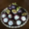 Bamboo plate filled with whole and cut-open mangosteens.