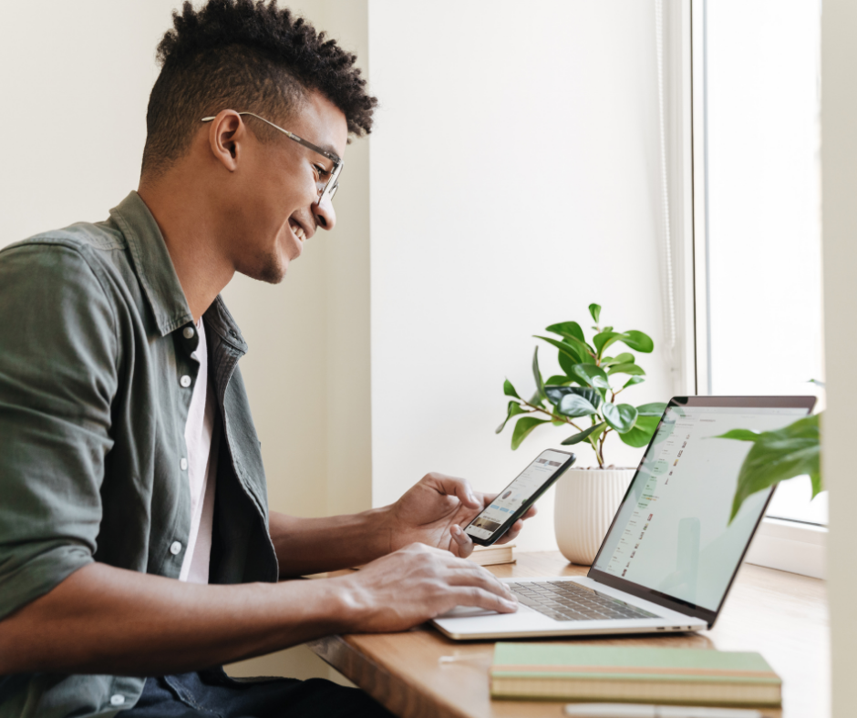 student looking at phone and laptop