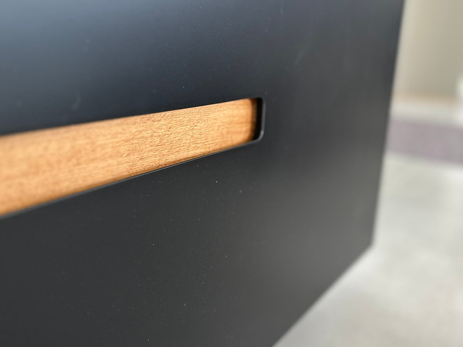Detailaufnahme einer integrierten Holzgriffmulde in einer TV-Wand nach Maß