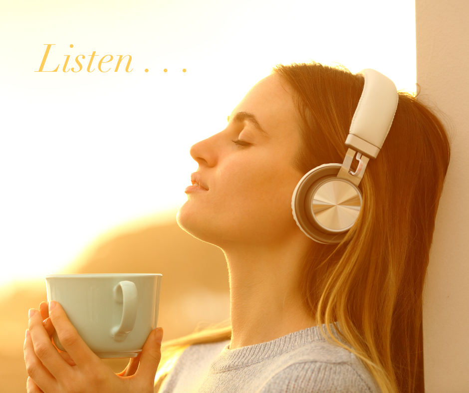 Woman with eyes closed, leaning back, listening with headphones, holding a mug, with golden sunlight
