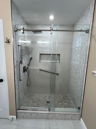 White wood slat shower with pebble stone floor