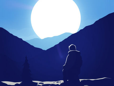 A person alone sitting by a lake