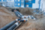 Laying heating pipes in a trench at construction site. Install underground storm systems o