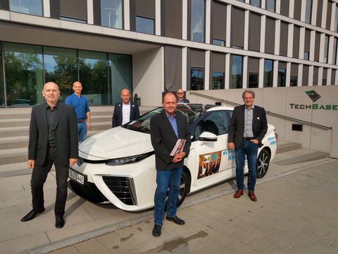 Das HyFuture Team vor einem weißen wasserstoffbetriebenen TOYOTA Mirai