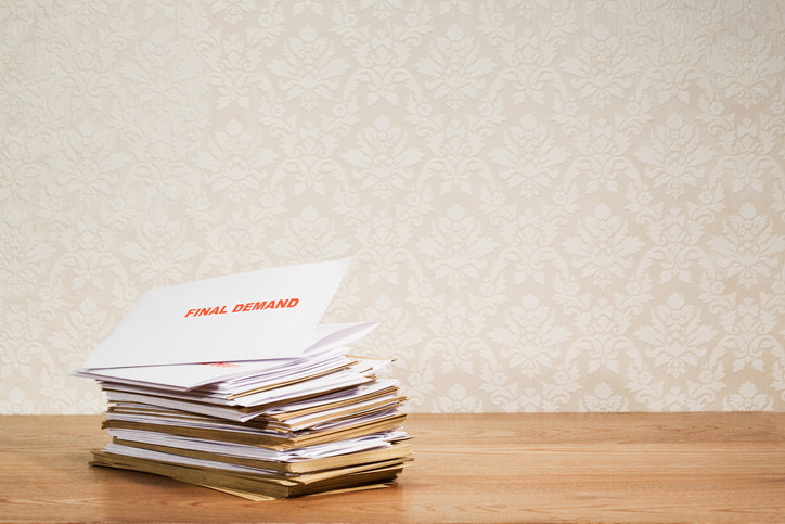 Stack of overdue bills signaling that a bankruptcy lawyer should be consulted for debt relief