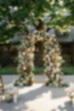 Romantic floral arch decorated with seasonal wedding flowers for ceremony backdrop