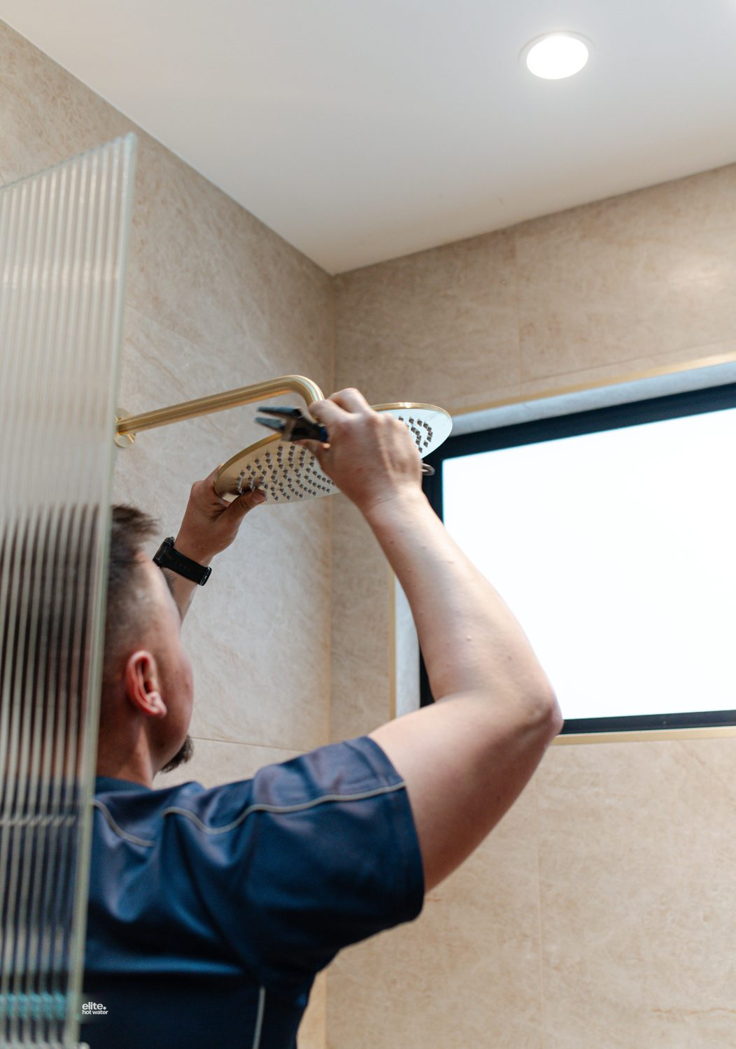 Elite plumber fitting a shower head