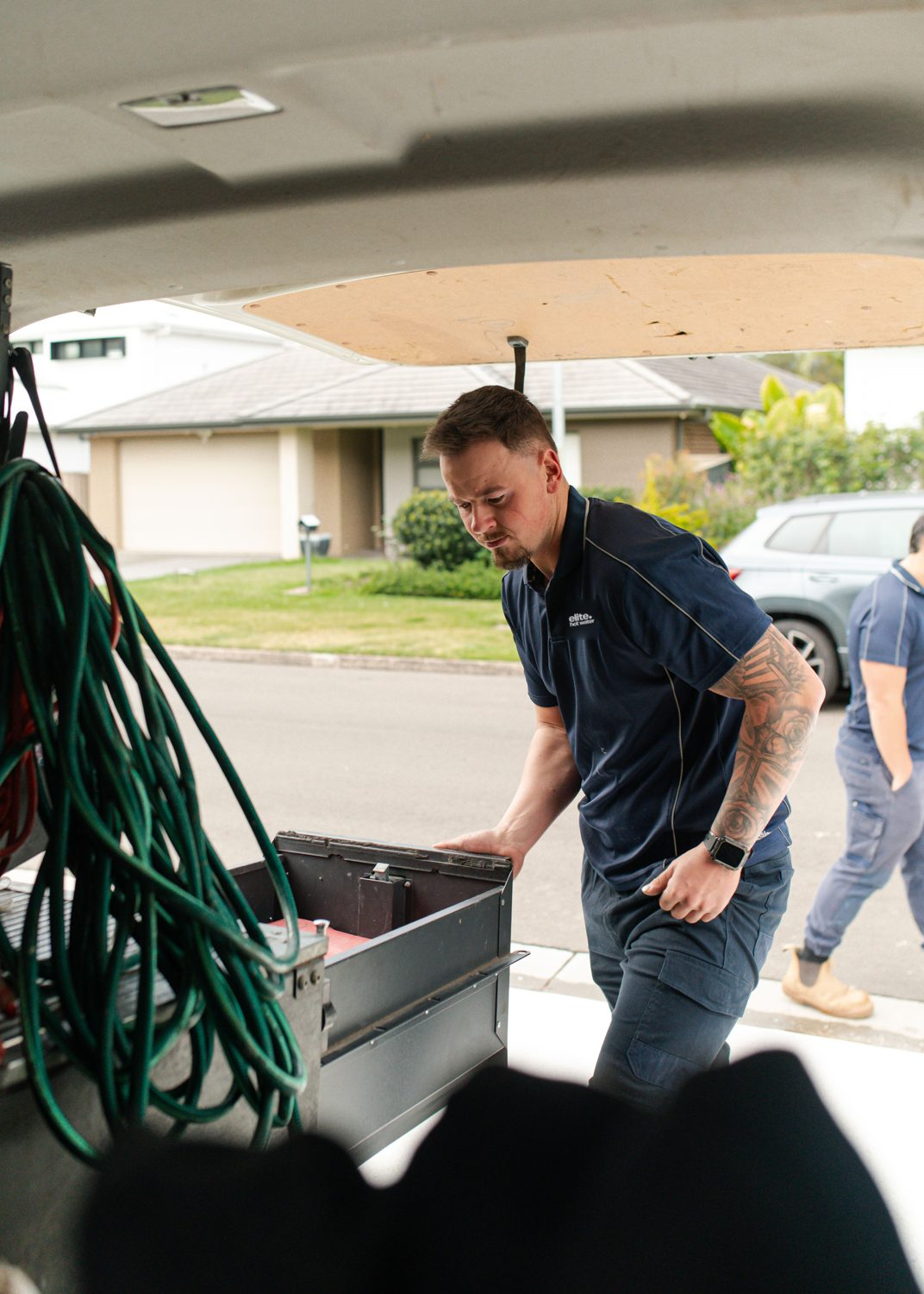 Elite plumber organising equipment in a service vehicle