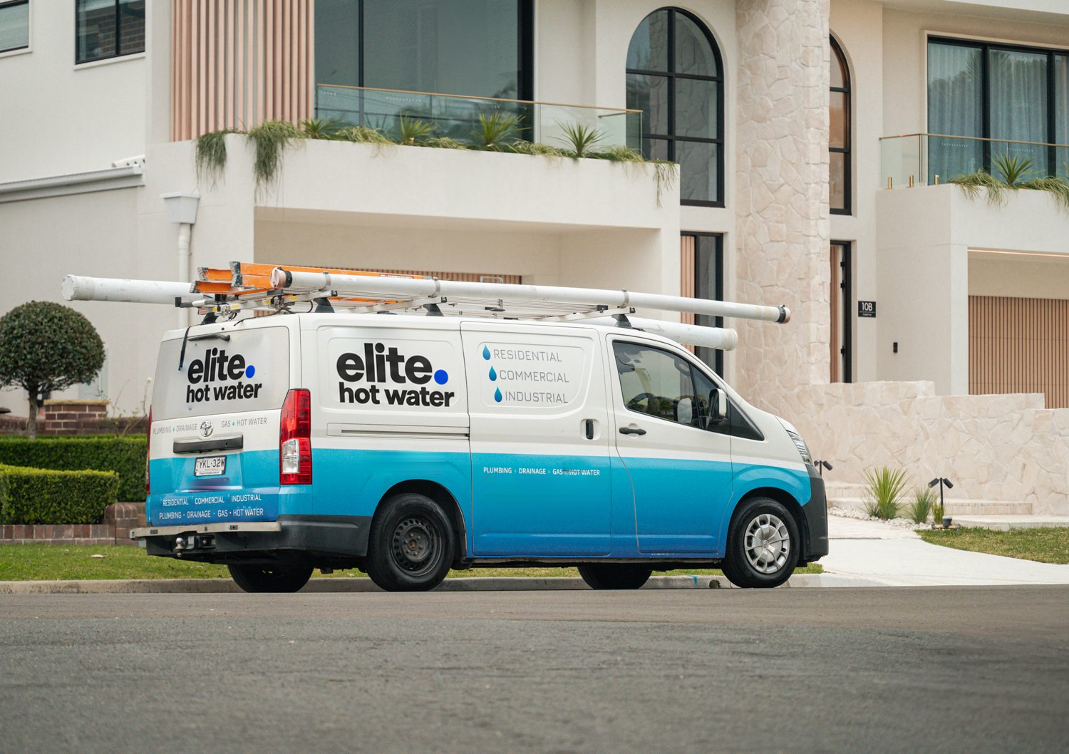 Elite Hot Water service van outside a home