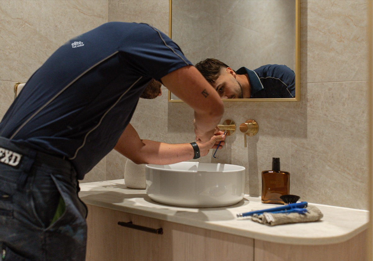 Elite plumber working on a bathroom tap