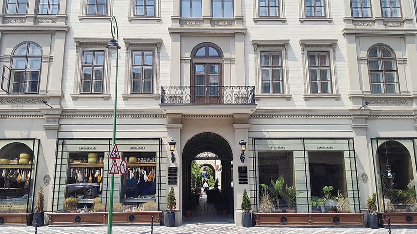 Cladire din centrul istoric al brasovului cu intrare in gang si vitrina de restaurant la parter.