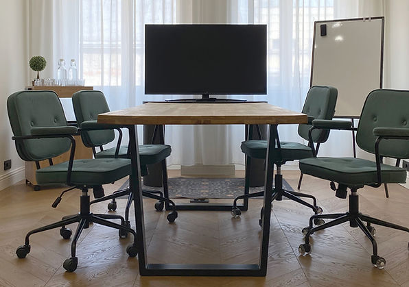 Sală de întâlniri în Brașov, la Kool Work, cu masă de conferință, scaune ergonomice, TV pentru prezentări și lumină naturală.
