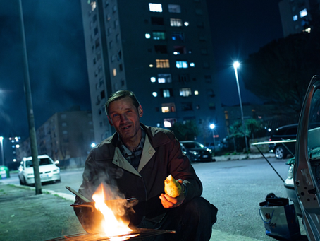 Un uomo cucina in mezzo alla strada. Foto di Fabio Moscatelli