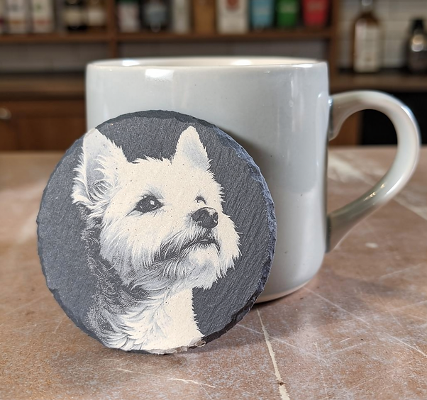 round slate drink coaster with an etched portrait of a West Highland dog portrait