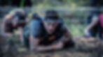 A man crawling under barbed wire as part of an assualt course to represent how hard it is to get content indexed on Google.
