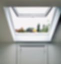 Supporting image for Barnet Loft Specialists showing an open loft window overlooking a grey sky and several colourful autumn trees.