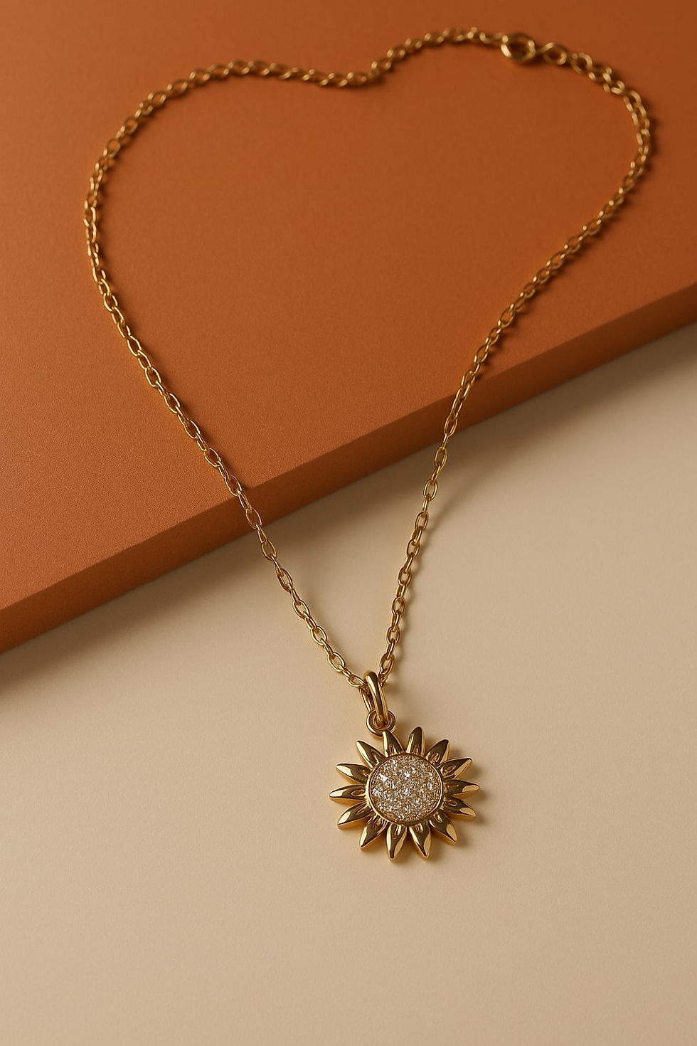 A sunflower-shaped anti-tarnish gold plated necklace with a sparkling American diamond center, displayed on a warm beige and