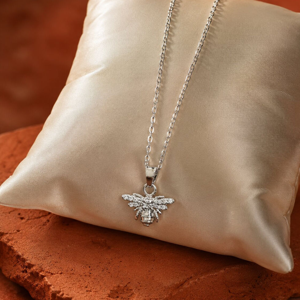 Bee Silver Necklace with sparkling crystal bee pendant displayed on a satin cushion with an elegant luxury background.