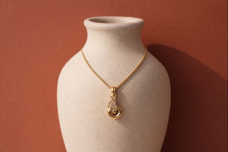 Elara Twist gold plated pendant necklace with elegant swirl design and subtle crystal detailing