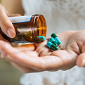 woman-s-hand-pours-medicine-pills-out-bottle.jpg