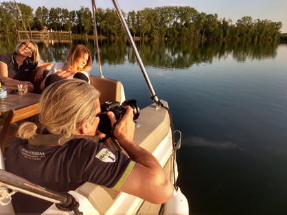Photographe prend des photos sur un bateau avec des amies, reflections sur l'eau.