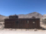 Old train cars and buildings pepper the landscape of the ghost town of Rhyolite