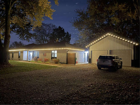 Warm white Christmas lights installed on a home and detached garage