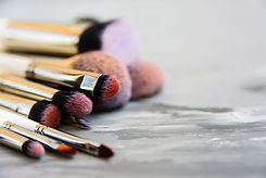 Set of different makeup brushes on gray background Copy space, soft focus.jpg