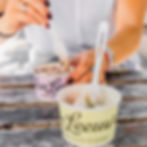 Two cups of Van Leeuwen ice cream on a wooden table