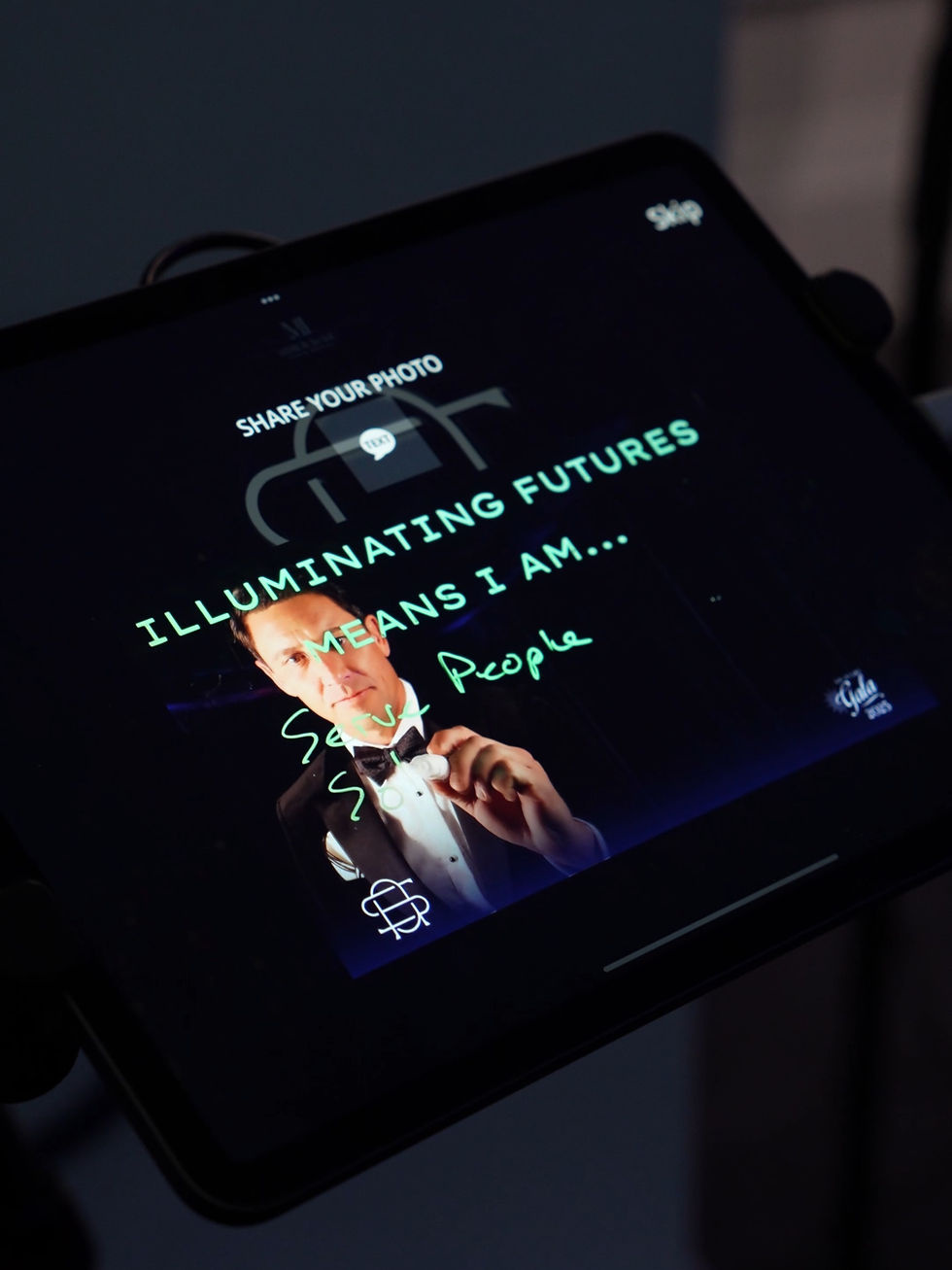 Gala guest writing โServe Peopleโ on the Scribble Booth glass screen during Son of a Saint Gala 2026 at Four Seasons New Orleans as the interactive video booth records in real time.