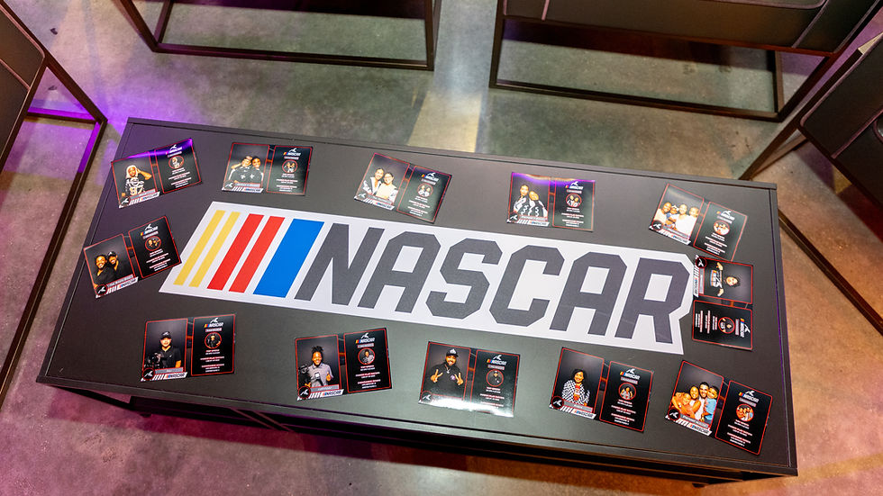 Display of custom NASCAR player cards featuring fans and influencers from the photo booth activation, arranged on a table with the NASCAR logo.