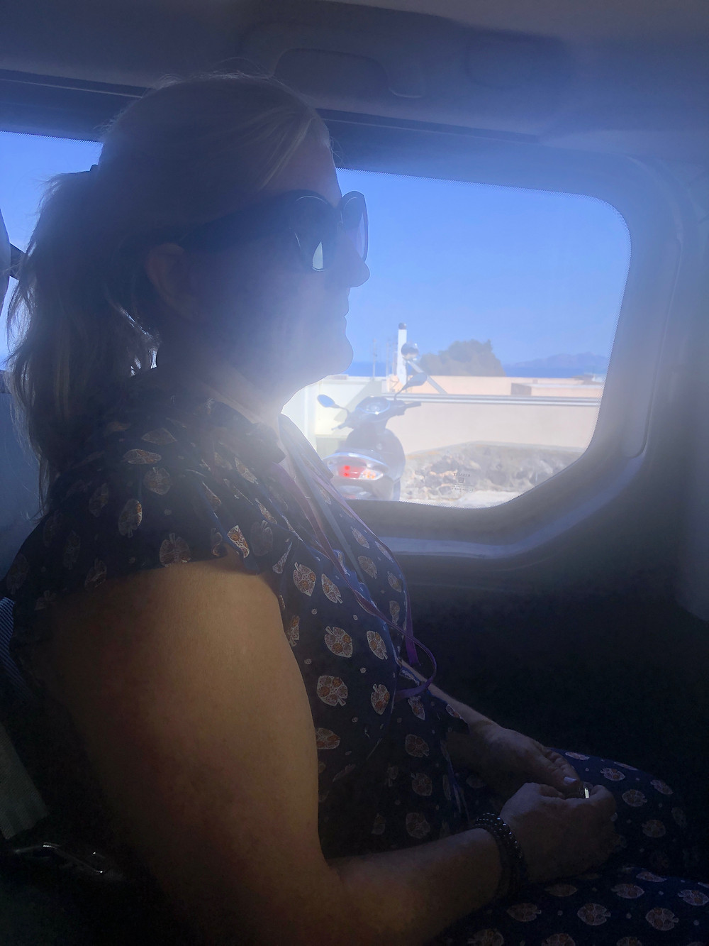 Siri Kay Jostad of Wander Away with Siri Kay riding in the back of a car on Santorini Greece