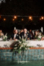 Wedding and event florals at a poolside reception table.