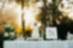 Outdoor wedding and event florals near a tiered cake at sunset