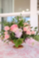 Pink wedding and event florals in a gold pedestal vase.