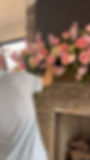 Florist arranging pink wedding and event florals on a mantel.