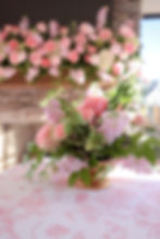Pink wedding and event florals on a patterned tablecloth.