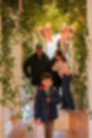 Family under lush wedding and event florals greenery archway.
