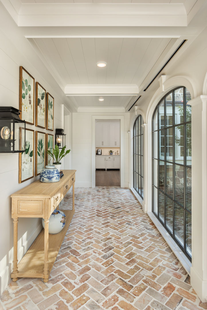 Brick hallway with arched doors and natural light in custom-built South Carolina lake home