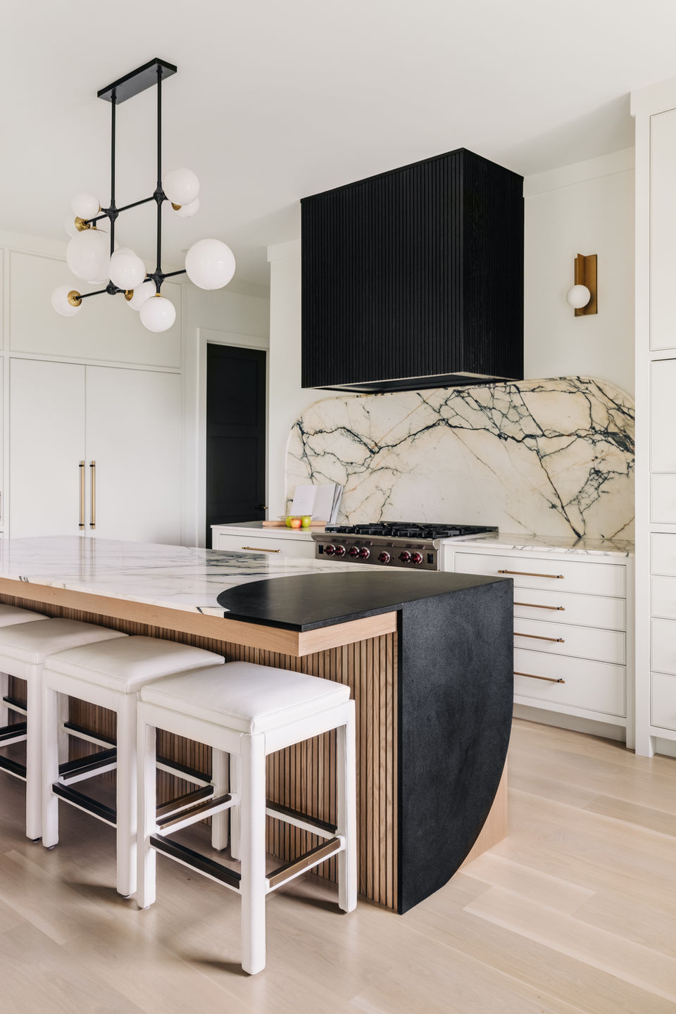 Black marble fireplace and TV wall in colorful yet elevated Six Mile residence