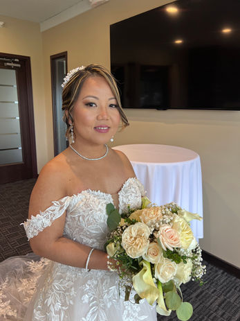 Bride in white lace wedding dress holding a floral bouquet