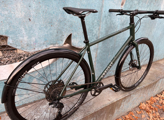 Nordest 3003 Custom-Build in Green Racing mit Stahl Diamant Rahmen, 28" DT Swiss Felgen, Shimano Naben, Maxxis Reifen, Shimano Cues 1x11 Antrieb mit 170mm 40Z Kurbel und 11–45 Kassette, Shimano Flatmount Bremsen. Lenker, Vorbau, Sattel und Sattelstütze von Ritchey Comp., Lizard Skins Griffe und Pelago Aluminium Schutzbleche, aufgebaut von Velo nah und fern.