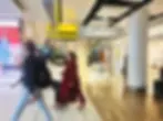 Travellers walking past Gucci store inside Heathrow Airport terminal