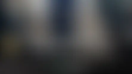 Business traveller arriving at Heathrow airport with luggage for chauffeur pickup.