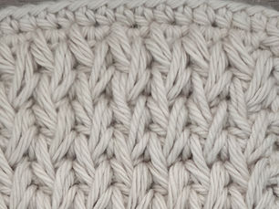 Close-up of yarn crocheted in the Feather stitch, showing elongated seven loop stitches spanning three placement points.