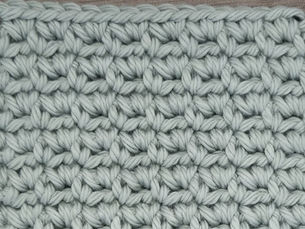 Close-up of yarn crocheted in the Sieve stitch, showing alternating rows of Single Crochet stitches and paired stitches worked into chain one spaces.