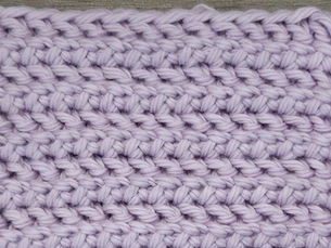 Close-up of lavender yarn worked in the Sable Stitch with alternating Herringbone Half Double Crochet and Slip Stitch rows.