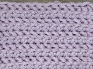 Close-up of lavender yarn worked in the Sable Stitch with alternating Herringbone Half Double Crochet and Slip Stitch rows.