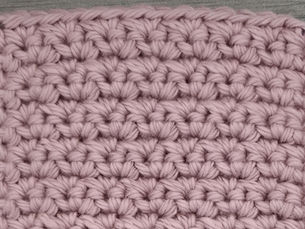 Close-up of pink yarn worked in the textured Grit Stitch